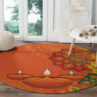 Round orange carpet featuring rangoli and diya motif with green and yellow accents