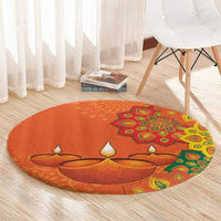 Round orange carpet with central diya design and colorful rangoli border
