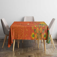 Saffron orange tablecloth with green rangoli motifs over rectangular table