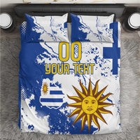 Blue and white bedding set with Uruguay map, sun face graphic, and 'YOUR TEXT' text