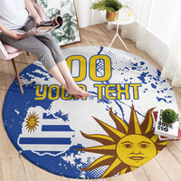 Round blue rug with Uruguay design and sun graphic, custom text; person walking