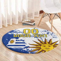 Round blue area rug featuring Uruguay flag, sun face graphic, and custom text