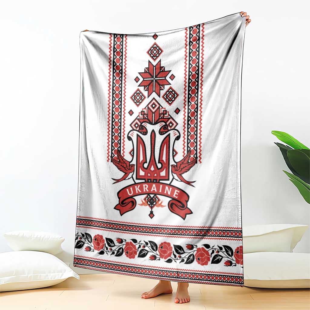 White blanket with red Ukrainian trident emblem and folk-pattern stripe and floral hem