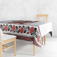White tablecloth with red and black floral and geometric folk band across the top
