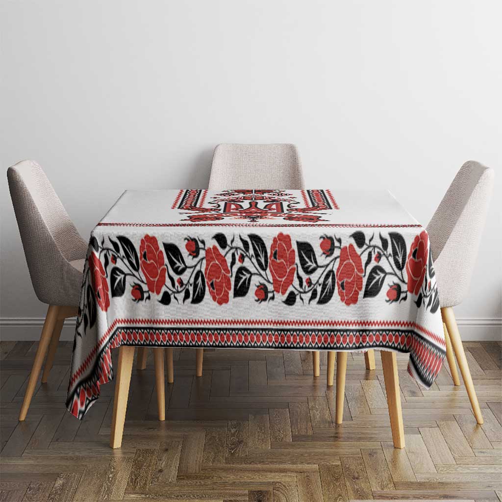 White tablecloth with red and black folk trident and floral pattern on dining table