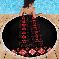 Round beach blanket with black field, red folk pattern, and white tassel fringe
