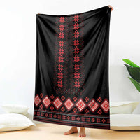 Folk pattern blanket: black with red vertical motifs and diamond border, hanging