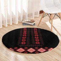Round black carpet with red folk geometric medallion and border stripe