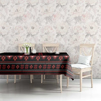 Black and red folk-pattern tablecloth on dining table with floral backdrop