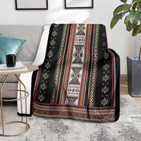 Black folk patterned blanket with red, white, and yellow geometric stripes and border