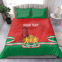 Personalized bedding set on bed: red-and-green duvet, green pillows, “YOUR TEXT,” crest