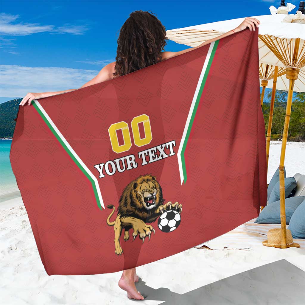Red football-style sarong with green border, lion-and-soccer ball graphic and “YOUR TEXT”