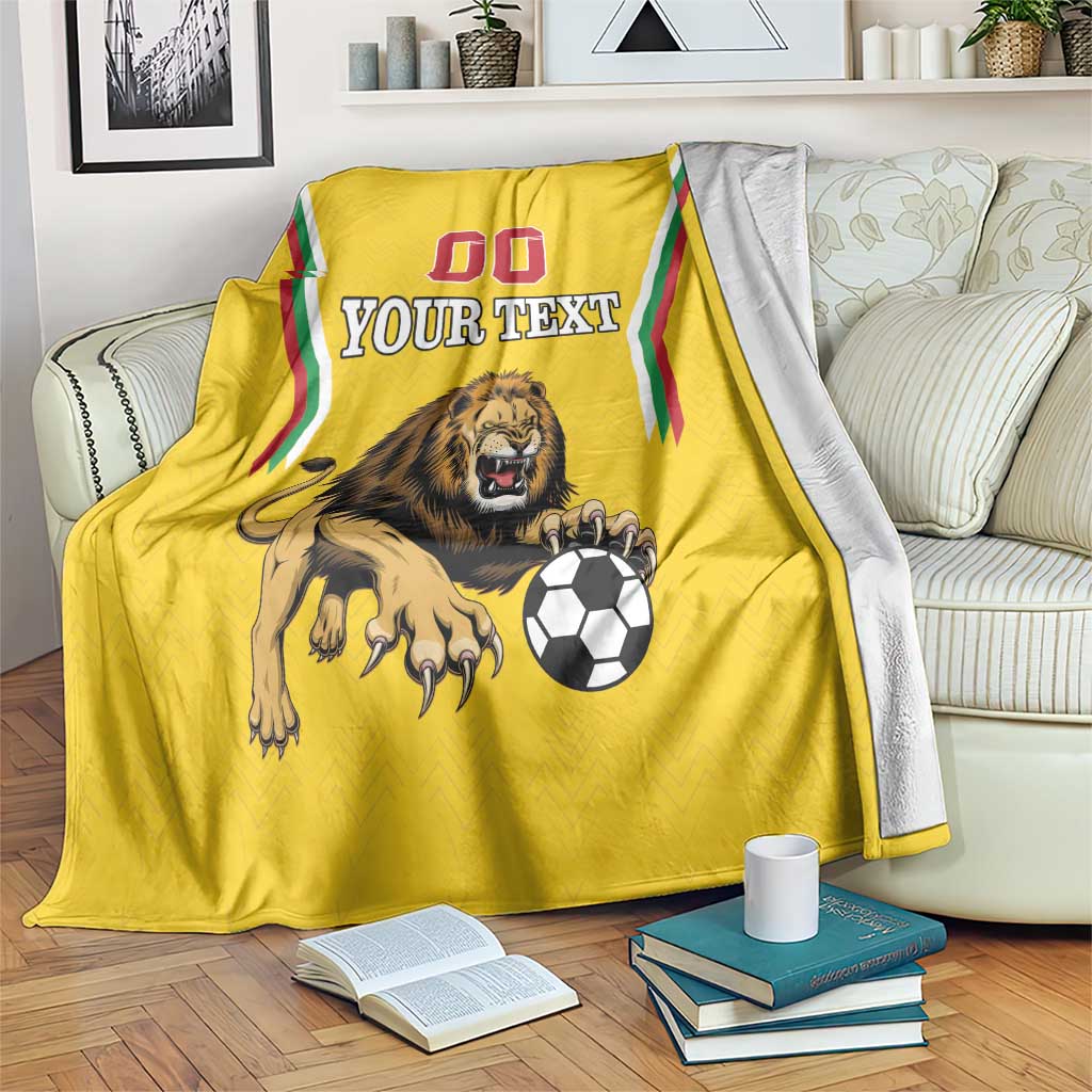 Yellow lion-themed football blanket draped over couch, 'Your Text' with soccer ball.