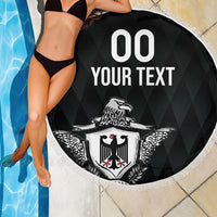 Black circular beach blanket with fringe edge, '00 YOUR TEXT' and eagle crest shield