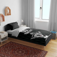 Black bedding set on bed with two pillows; centered eagle crest graphic on duvet.