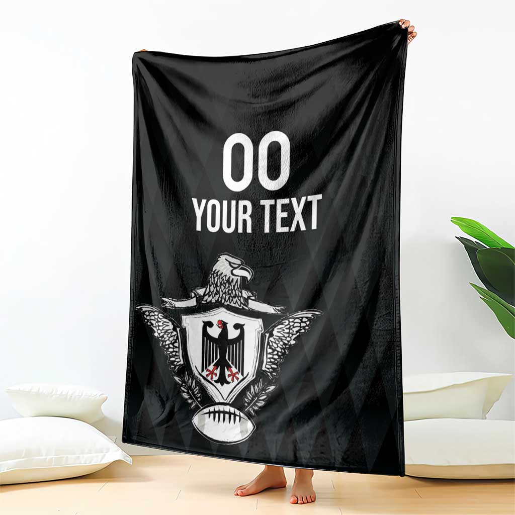 Black rugby blanket with eagle crest and '00 YOUR TEXT' print, held upright