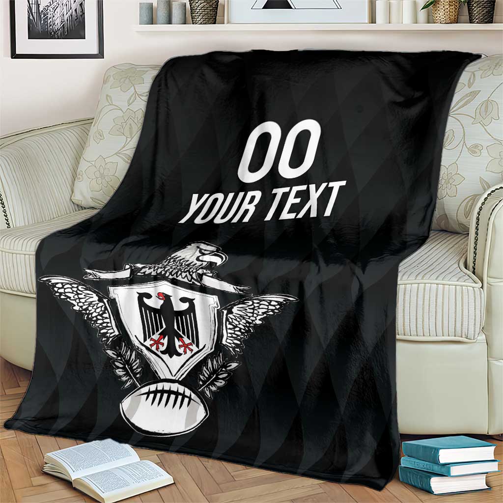 Black rugby blanket with eagle crest and '00 YOUR TEXT' print, draped over loveseat