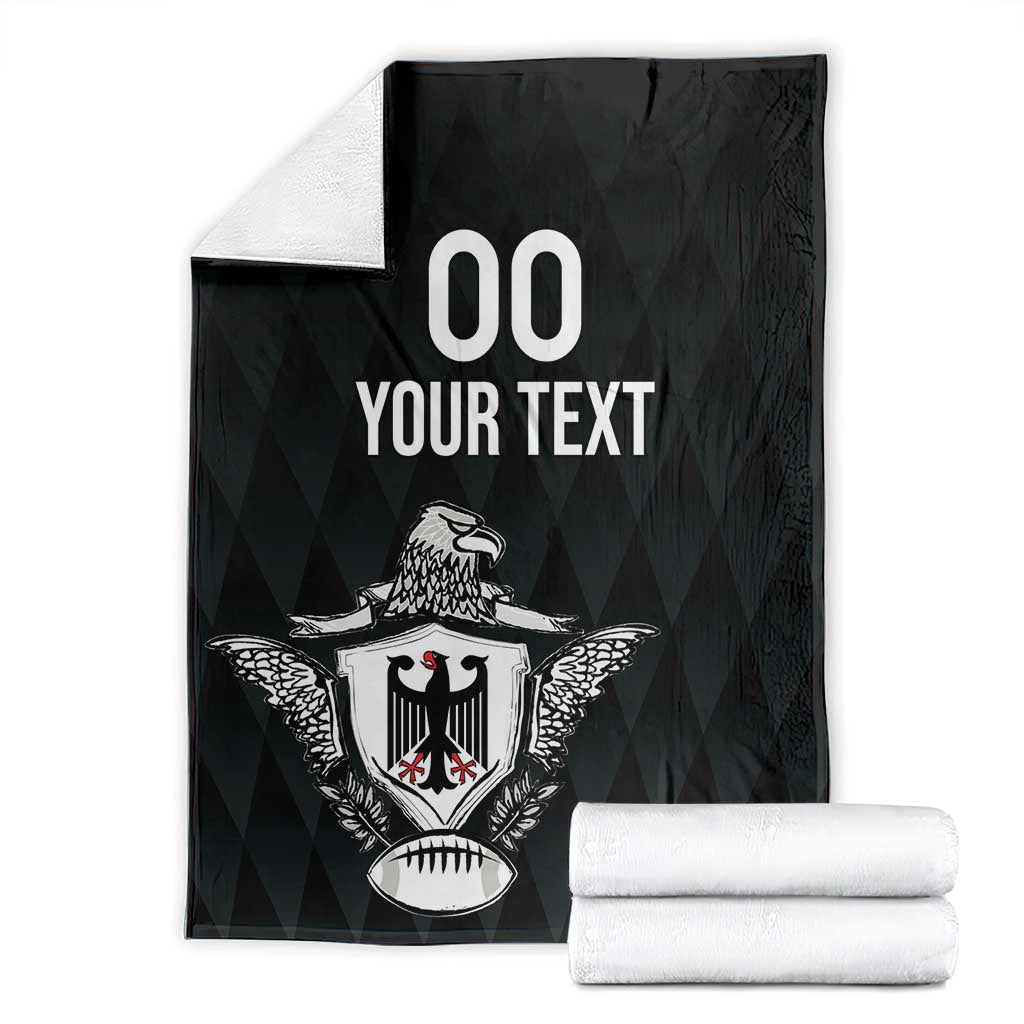 Black rugby blanket with eagle crest and '00 YOUR TEXT' print, folded with rolls