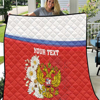 Red quilt blanket with white top panel, blue stripe, and coat of arms with flowers