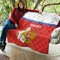 Red quilt blanket with white top and blue stripe, “YOUR TEXT”, coat of arms and flowers