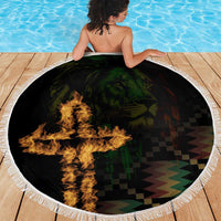 Round black beach blanket with white fringe, flames over dark emblem and checkered zigzag