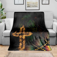 Black printed blanket spread on grey sofa, with lion face and cross flame and geometric stripes