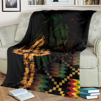 Black printed blanket on couch, featuring lion and cross flame design with multicolor zigzag hem