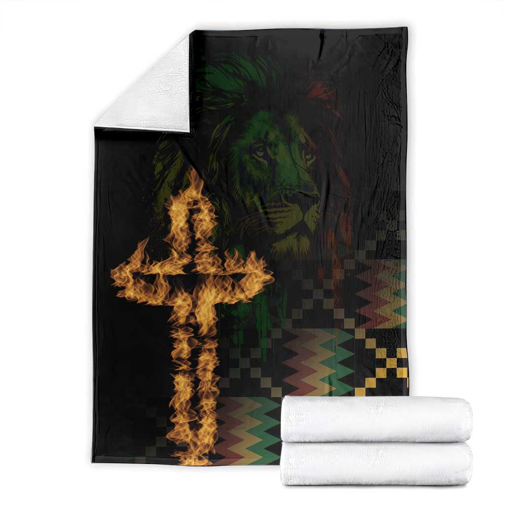 Black printed blanket with lion and cross flame design, folded with rolled towels