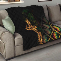 Black quilt blanket draped on sofa, diamond stitching, flaming cross and geometric strip