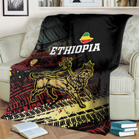 Meskel Ethiopia blanket on armchair, black with gold lion, ETHIOPIA text, and grunge stripes