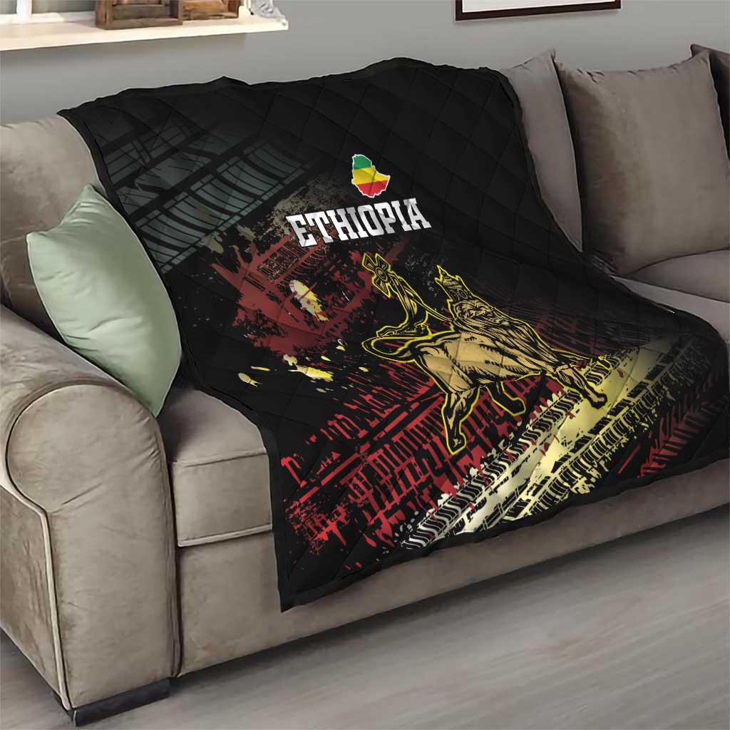 Black Ethiopia quilt folded on sofa with diamond stitching and Lion of Judah graphic, ETHIOPIA text.