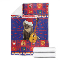 Folded Christmas blanket, red and blue plaid with koala in Santa hat and guitar, Merry Christmas