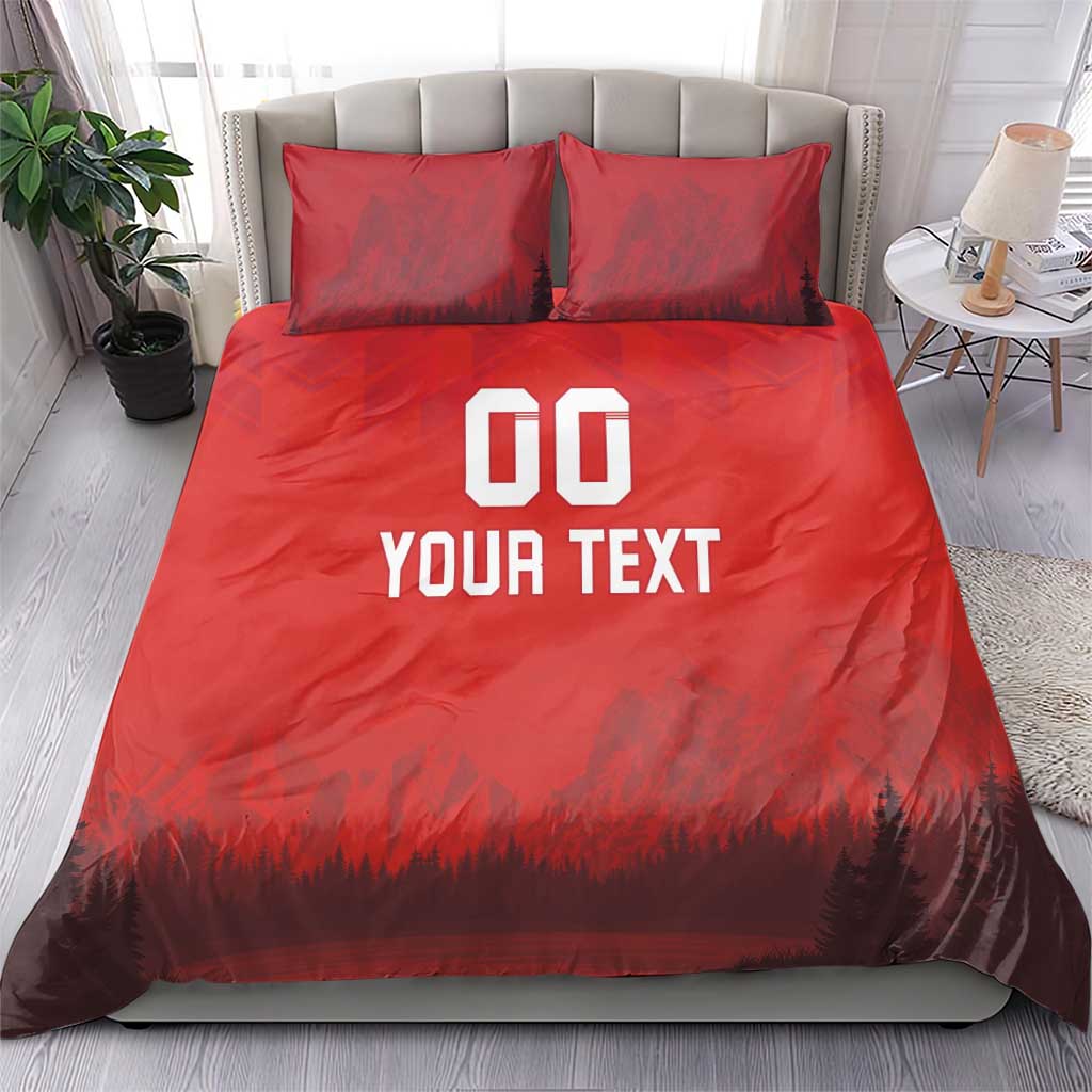 Red duvet set with 'DO YOUR TEXT' print and forest-mountain scene; two pillows