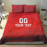 Red duvet set with 'DO YOUR TEXT' print and forest-mountain scene; two pillows