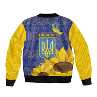 Blue and yellow bomber jacket with folk crest and sunflowers, back graphic, ribbed hem