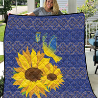 Blue quilt with yellow sunflower and dove motif, framed by a blue folk pattern.