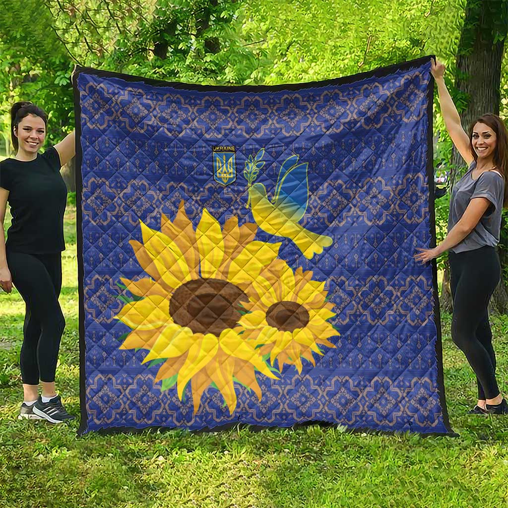 Blue quilt outdoors, showing yellow sunflower and dove over a blue folk pattern.