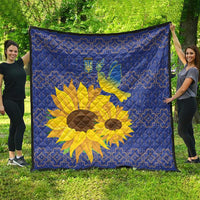 Blue quilt outdoors, showing yellow sunflower and dove over a blue folk pattern.