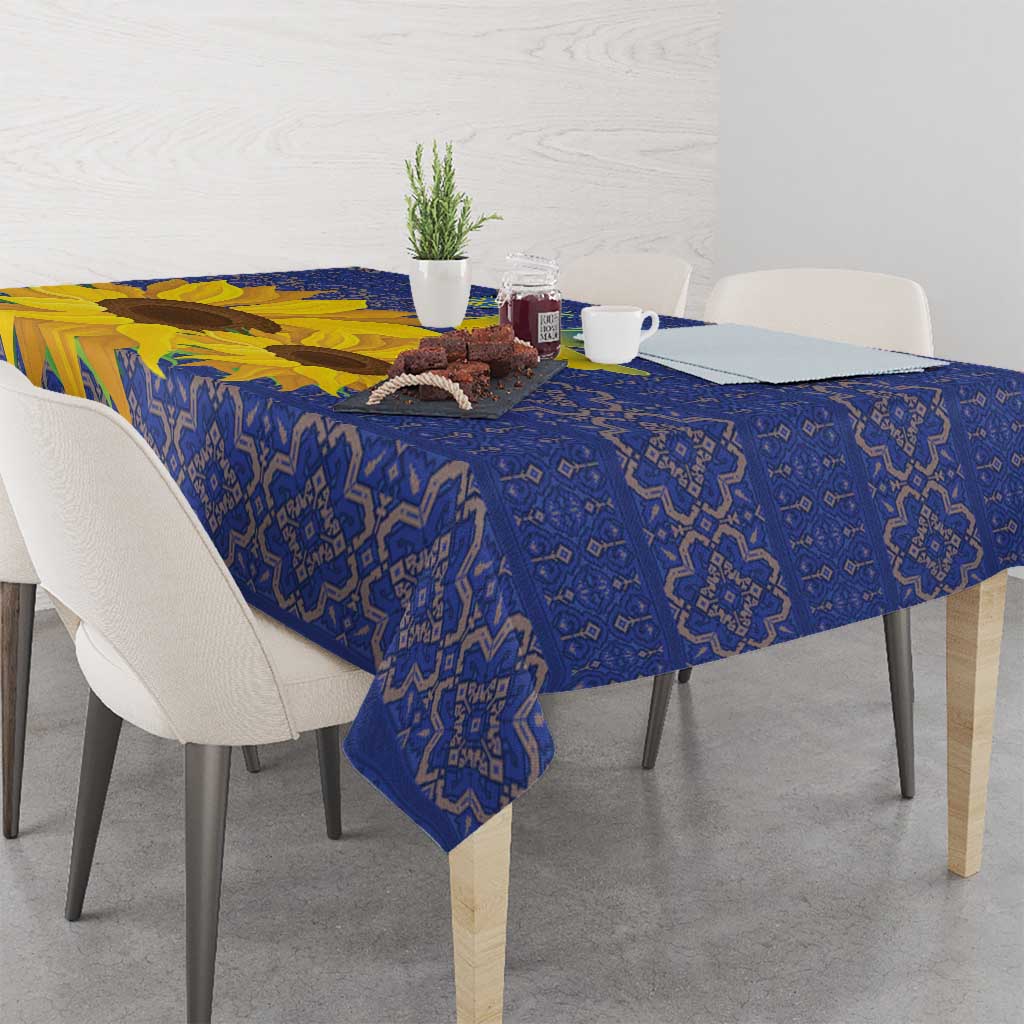 Blue tablecloth with repeating folk motifs and bright yellow sunflower edge