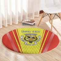 Round red and yellow rug with crest emblem and 'YOUR TEXT' banner on center
