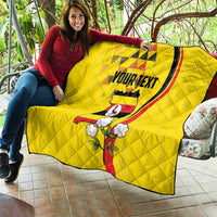 Yellow personalized quilt draped over sofa with Uganda motif, red stripe, and “YOURTEXT”