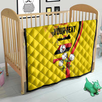 Yellow personalized quilt in a baby bed with Uganda motif and “YOURTEXT” panel