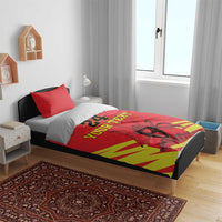Red duvet with “YOUR TEXT” and kente striped design across the bed surface
