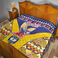 Personalized blue and yellow quilt with condor emblem, “Your Text,” and geometric trim on bed.