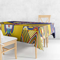 Blue and yellow tablecloth with multicolor geometric pattern, draped over bench and table