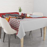 Red tablecloth detail with Vytis emblem, geometric lattice pattern, and draped corners.