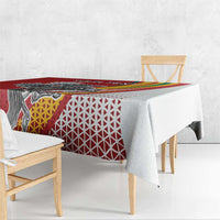 Red tablecloth with Vytis emblem and white geometric pattern; rainbow stripe runs across.