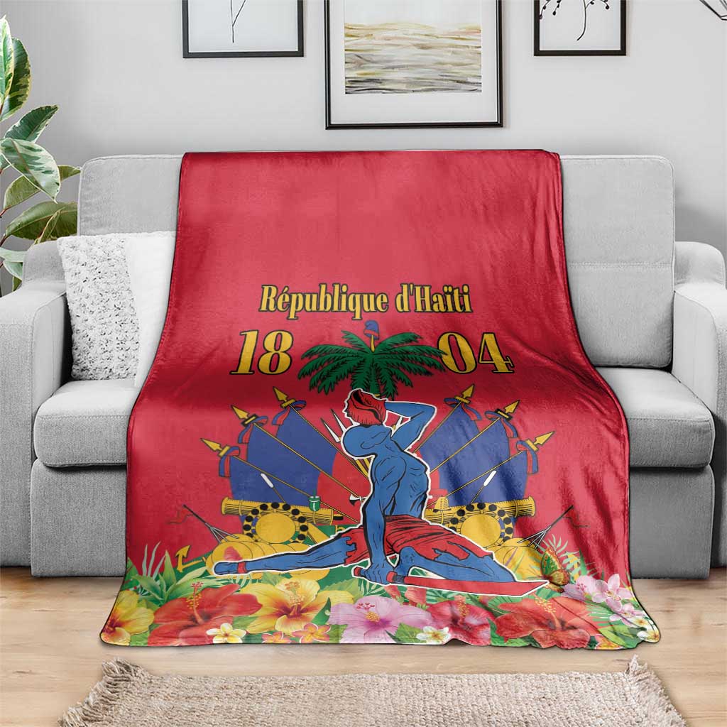 Red Haiti independence blanket on gray sofa with palm tree and illustrated central figure