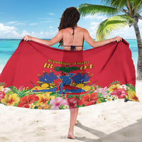 Red sarong beach wrap with Haiti emblem and floral artwork, held open around the body