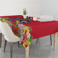 Red tablecloth with tropical floral print and multicolor border draped on table